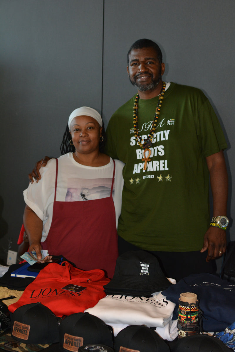 Two people standing behind a display of clothing and accessories.