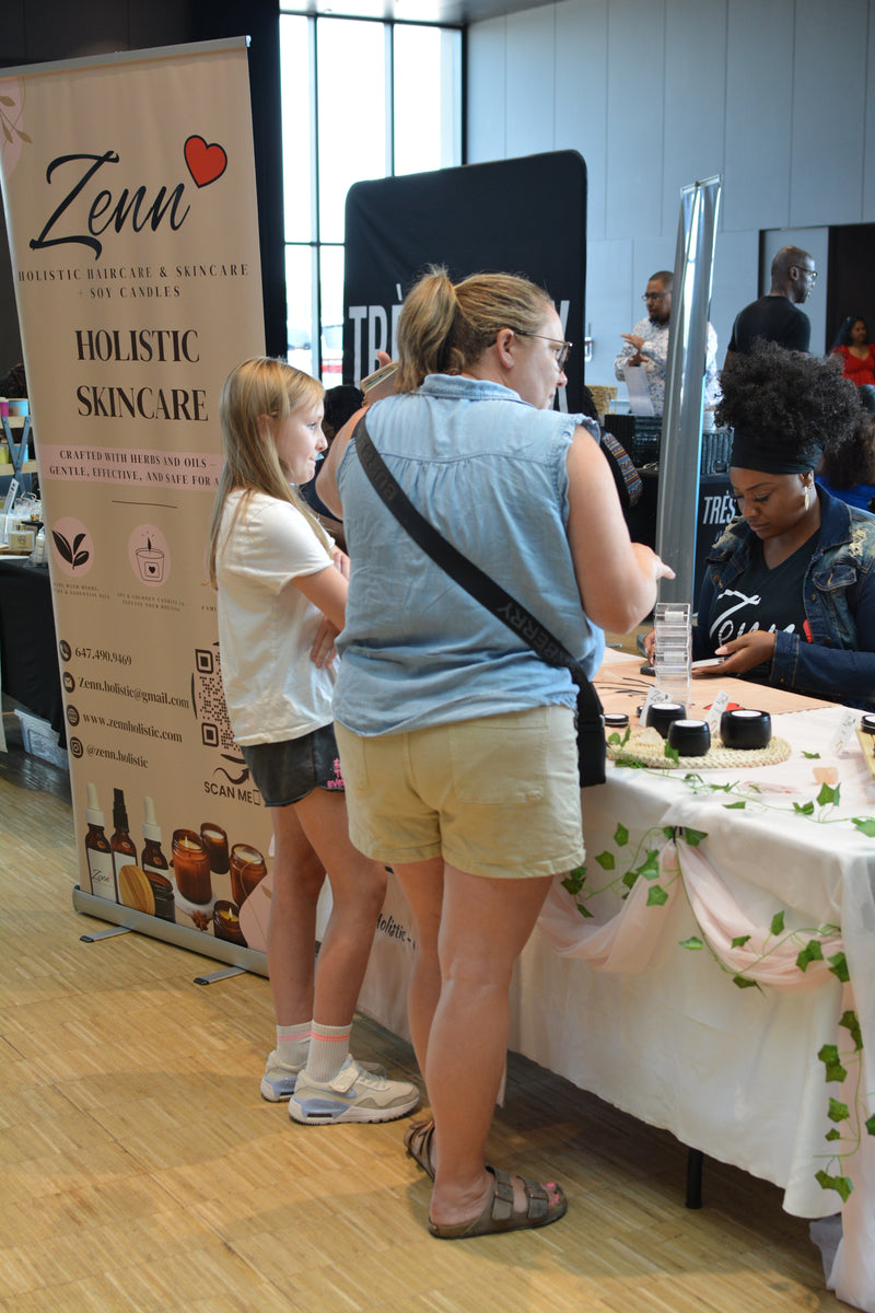 Woman standing at a table with Zenn Holistic Skincare branding in the background